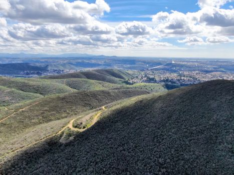 Aerial view of Black Mountain in Carmel Valley, San Diego, California, USA. Green dry mountain during sunny cloudy day with hiking trails, perfect for sport activity an leisure time..