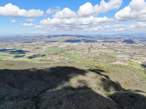 Aerial view of Black Mountain in Carmel Valley, San Diego, California, USA. Green dry mountain during sunny cloudy day with hiking trails, perfect for sport activity an leisure time..