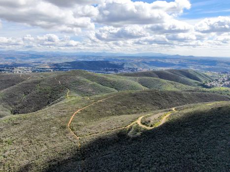 Aerial view of Black Mountain in Carmel Valley, San Diego, California, USA. Green dry mountain during sunny cloudy day with hiking trails, perfect for sport activity an leisure time..