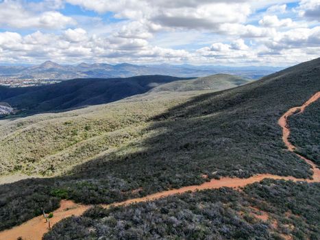 Aerial view of Black Mountain in Carmel Valley, San Diego, California, USA. Green dry mountain during sunny cloudy day with hiking trails, perfect for sport activity an leisure time..