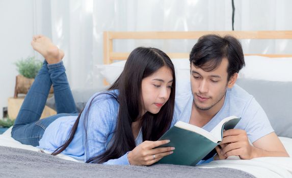 Couple reading a book together in bedroom on the morning with happiness.