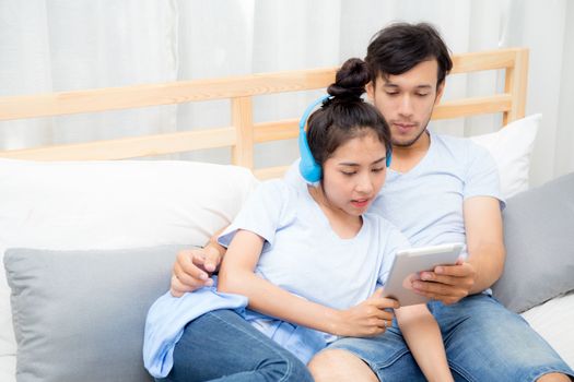 Beautiful asian young couple listening to music with tablet on bed, Love, dating,Young couple in sitting together in bed using a Tablet.