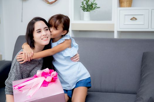 happy of mother and daughter asian with gift with pink ribbon and daughter kissing mother, Happy family concept. Happy mother's day.