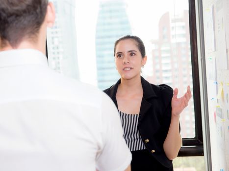 American business woman in modern office looking report and analyzing with talking people in meeting room.