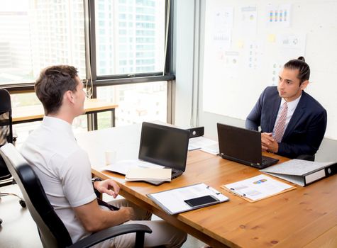 American young businessmen interacting and talking teamwork at meeting in office.