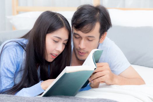 Couple reading a book together in bedroom on the morning with happiness.