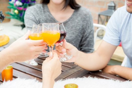 Asian group people drinking at party outdoor. group of friends cocktails in hand with glasses.close up on hand holding beverage.