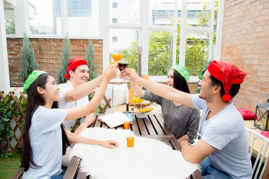 Asian group people drinking at party outdoor. group of friends cocktails in hand with glasses.