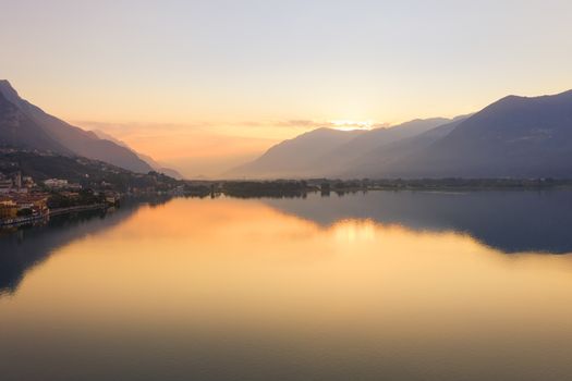 Drone view of Lake Iseo at sunrise, on the left the city of lovere which runs along the lake,Bergamo Italy.