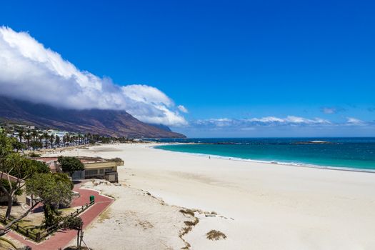 Camps Bay Beach and Table Mountain with clouds in Cape Town, South Africa.