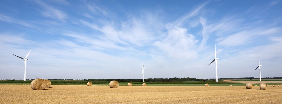 fields and wind turbine in french part nord pas de calais under blue sky in summer