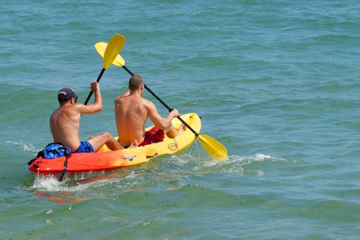 Varna, Bulgaria - July, 31,2020: two young men are sailing on a kayak in the sea