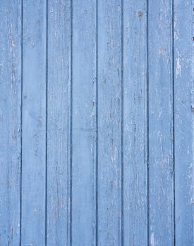 background consisting of cracked bright blue paint on vertical wooden planks