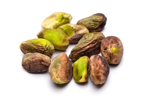 Pile of roasted pistachio nuts seeds (Pistacia vera) isolated on white