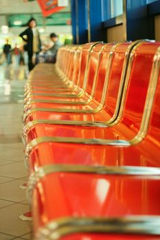 Empty red metal seats at airport hall