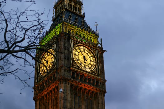 Detail of clock on Big Ben in London, United Kingdom illuminated by lights in evening