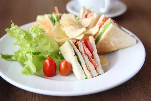 Club sandwich with coffee on wood background