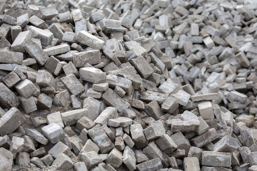 Pile of dismounted gray modern urban pavement bricks with selective focus. Result of russian government corruption in city infrastructure renovation.