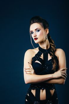 white girl modell on a dark background in a dress made of cut stripes of black fabric