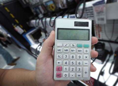 Man left hand holding a handy calculator and shoot in electronic store Tokyo Japan.