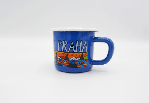 Small tiny and blue colour with hand made art souvenir coffee cup from Praque Czech Replublic and studio shot on white background.