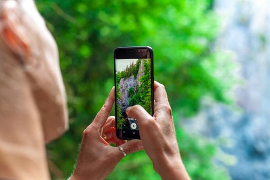 young woman shooting nature video with smartphone.