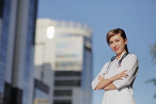 Portrait of a beautiful female doctor or nurse in the city. Skyscraper, sky. Prevention Covid-19 healthcare concept. Stethoscope over the neck. Woman, girl.