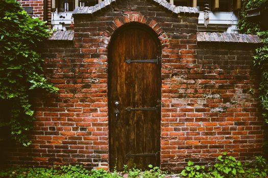 An Old Wooden Door in a Worn Brick Facade