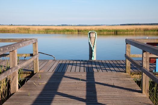 Old wooden pier with railing and wooden pile at the Baltic Sea