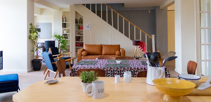 Modern room with brown armchair and stairs in the background. flowery dining room