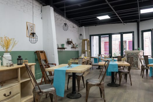 Interior of coffee shop, with wooden tables and blue tablecloth. empty restaurant