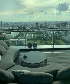 Relaxing sitting area with a view of tall buildings in the capital city of Bangkok.