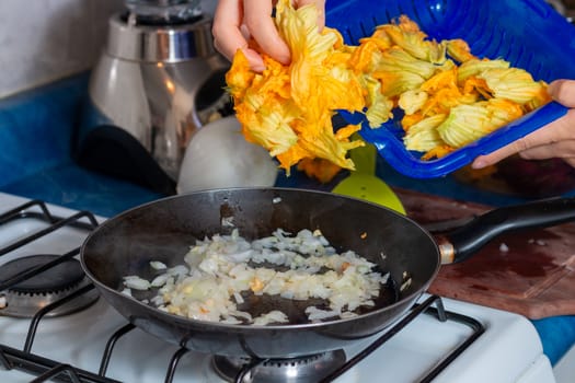 chopped onion put into the pan to fry with pumpkin blossom. Home cooking