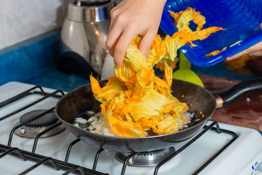 chopped onion put into the pan to fry with pumpkin blossom. Home cooking