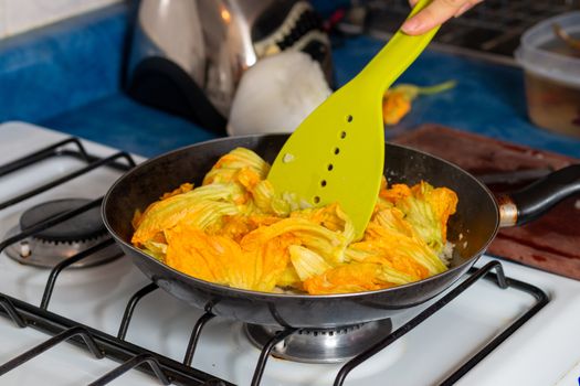 chopped onion put into the pan to fry with pumpkin blossom. Home cooking