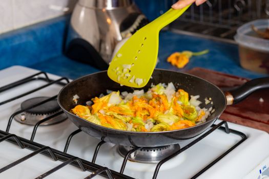 chopped onion put into the pan to fry with pumpkin blossom. Home cooking