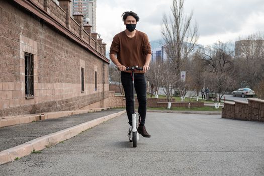 Young man riding a scooter in the city