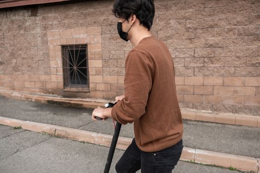 Young man riding a scooter in the city