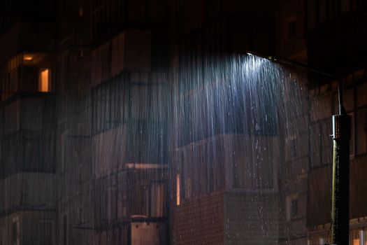 lamp post at rainy nigh with selective focus and long exposure motion blur of rain drops.