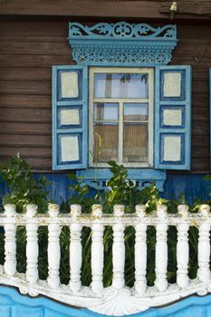 Wooden lacy architecture of old houses in Belarus. Carved wooden decorative upper part of the wooden windows of the building. Vertical image