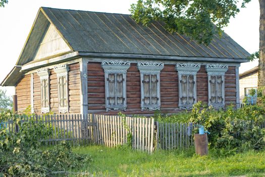 Carved wooden trim of the facade of the old house. Authentic house with carved wooden facade, Belarus