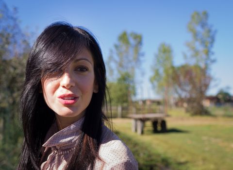 A young country girl hints at a smile, looking far.