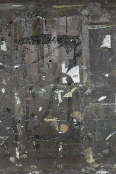 Empty notice board of dark metal, covered with remnants of tape torn.