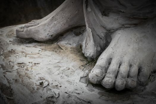 Detail of a marble statue, depicting the foot of the suffering Christ