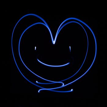 Heart smiling generated by a beam of white light, with long exposure.