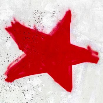 A red star painted on the wall with spray paint.