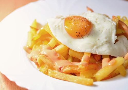 A Plate of French Fries with Fried Egg and Chilli Mayonnaise.