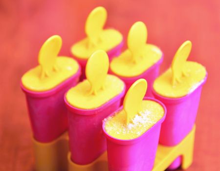 Homemade popsicles in pink ice cream plastic makers or molds.