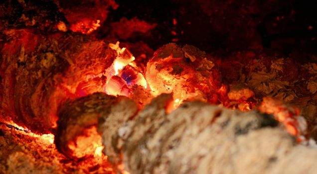 View into a fireplace with close up of a blazing burning logs.