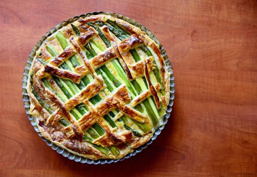 Directly above  top view of an Asparagus cake with puff pastry, cheese, ham and spinach in the one pan.